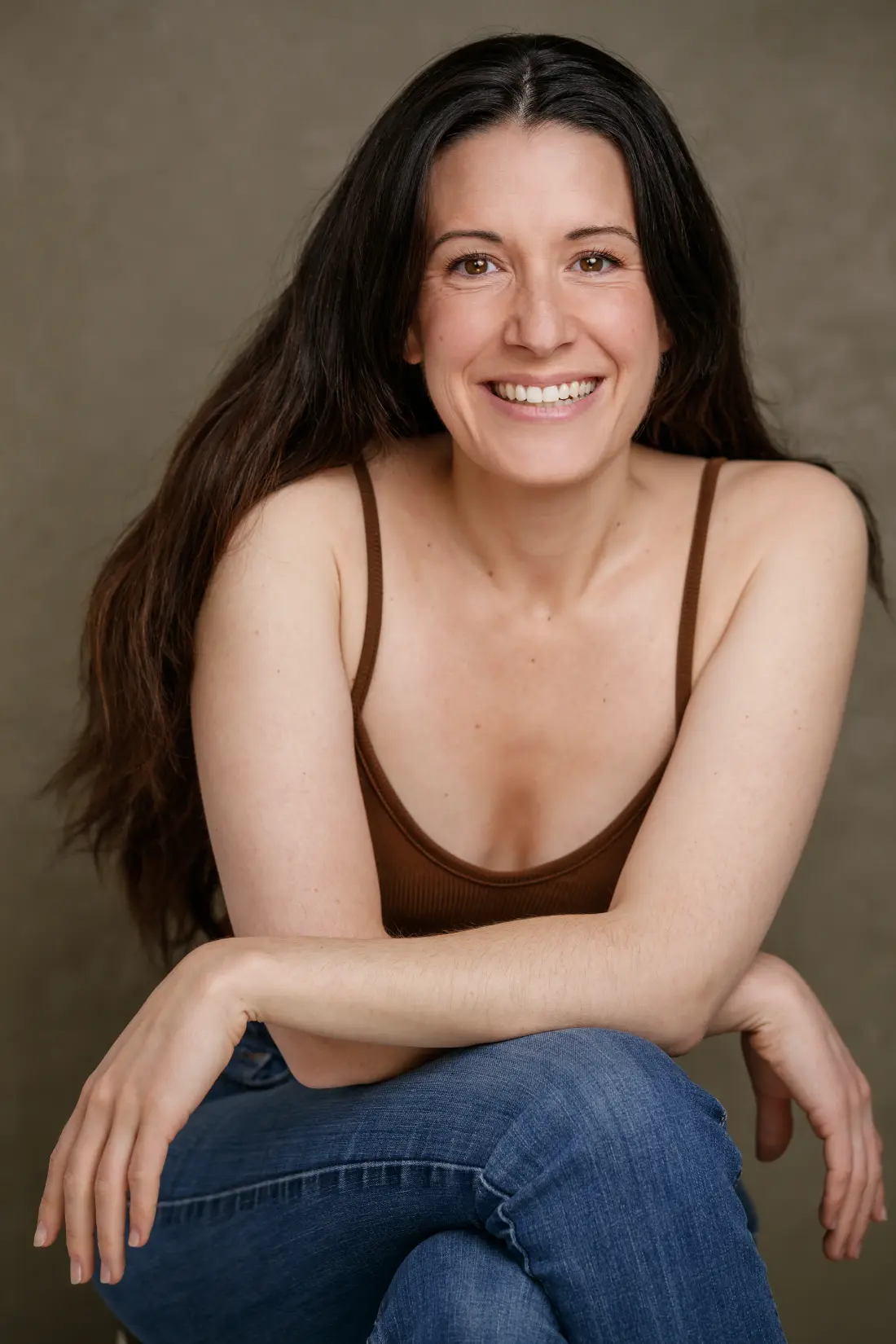 Portrait de Camille Gondard, souriante, assise, les mains posées sur les genoux