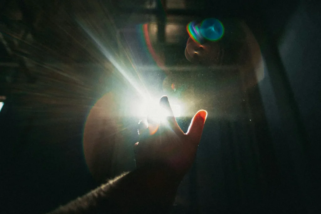 Main levée vers un éclat de lumière dans la pénombre